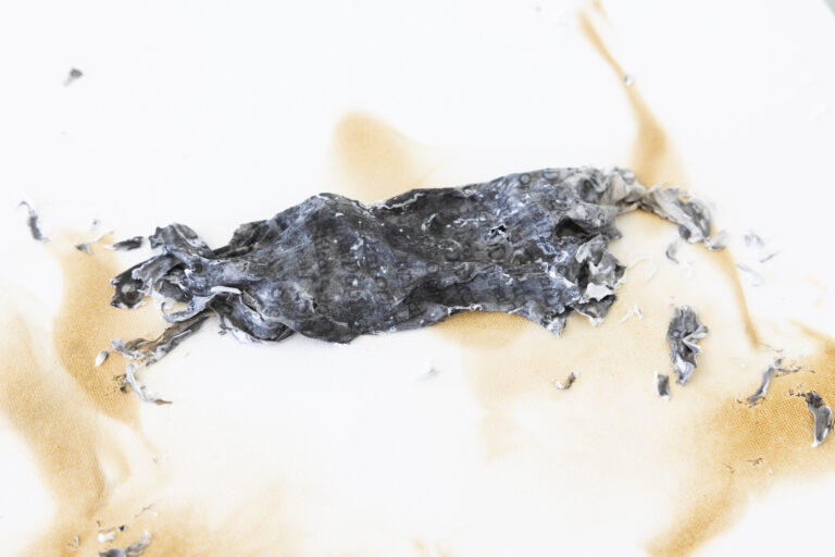 Amina Brotz, remis (Gerichtetes Vergessen), 2023, Rauminstallation; Malplatte, Sockel, Stempeldruck auf verbranntem Löschpapier