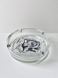 Sabine Schellhorn, RZ-Asche, 2026, Papierschnitt in Aschenbecher, 14 x 14 x 4 cm