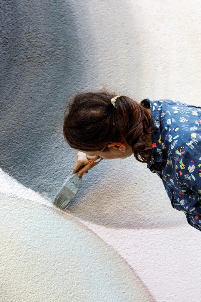Nahaufnahme von Marina Schulze bei der Arbeit an ihrem Fassadenkunstwerklook in am Zentrum für Kunst, Foto: Frank Scheffka